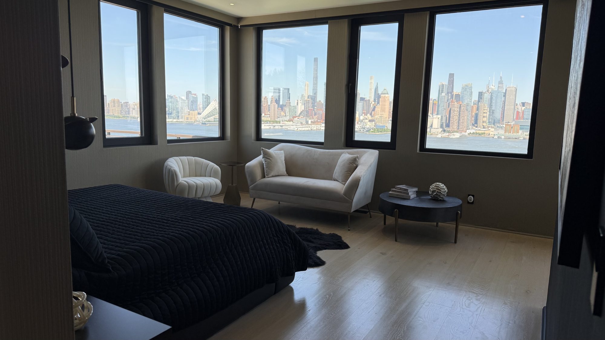 Primary bedroom with corner skyline views and sitting area