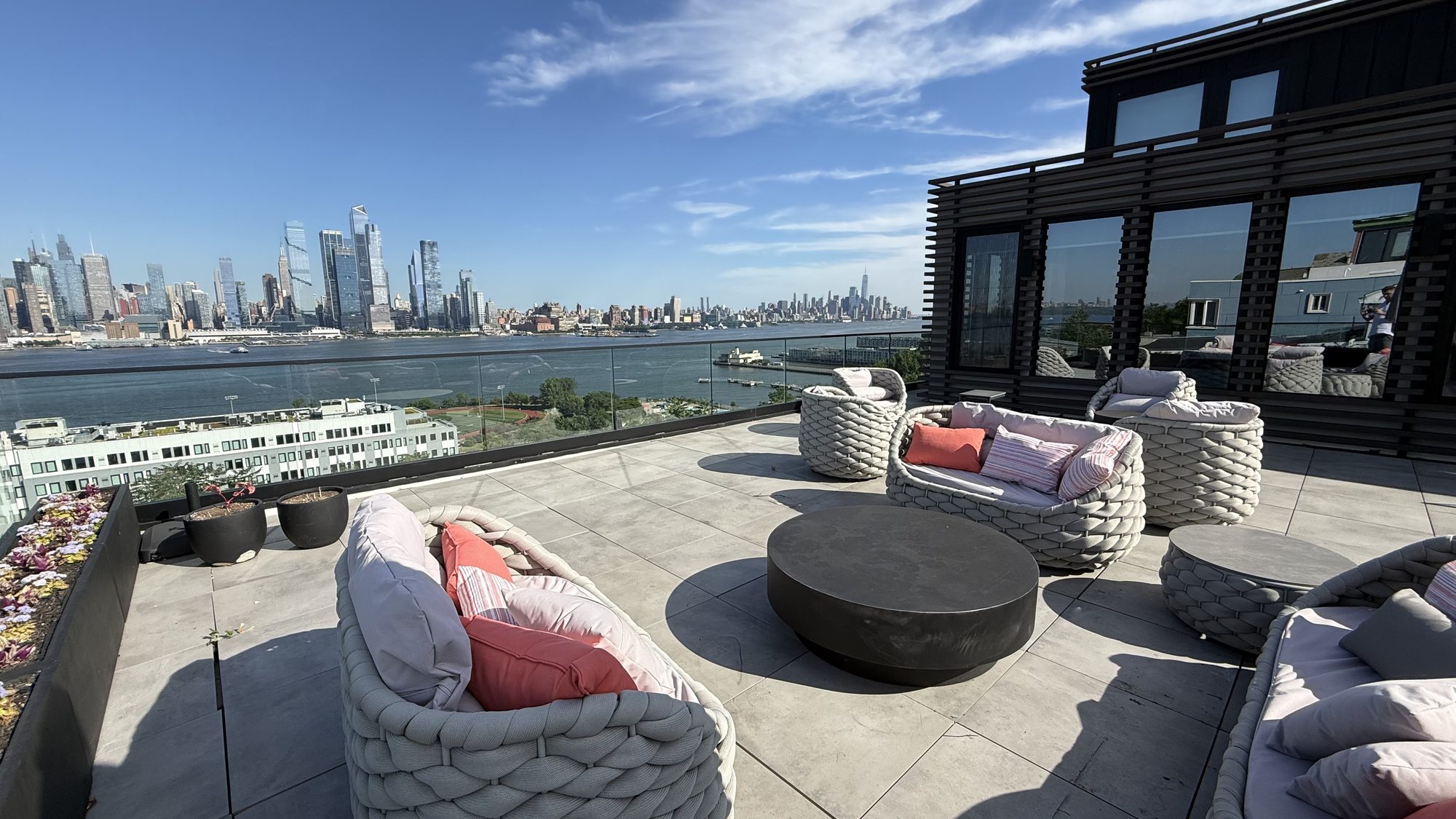 Glass-enclosed rooftop terrace with skyline