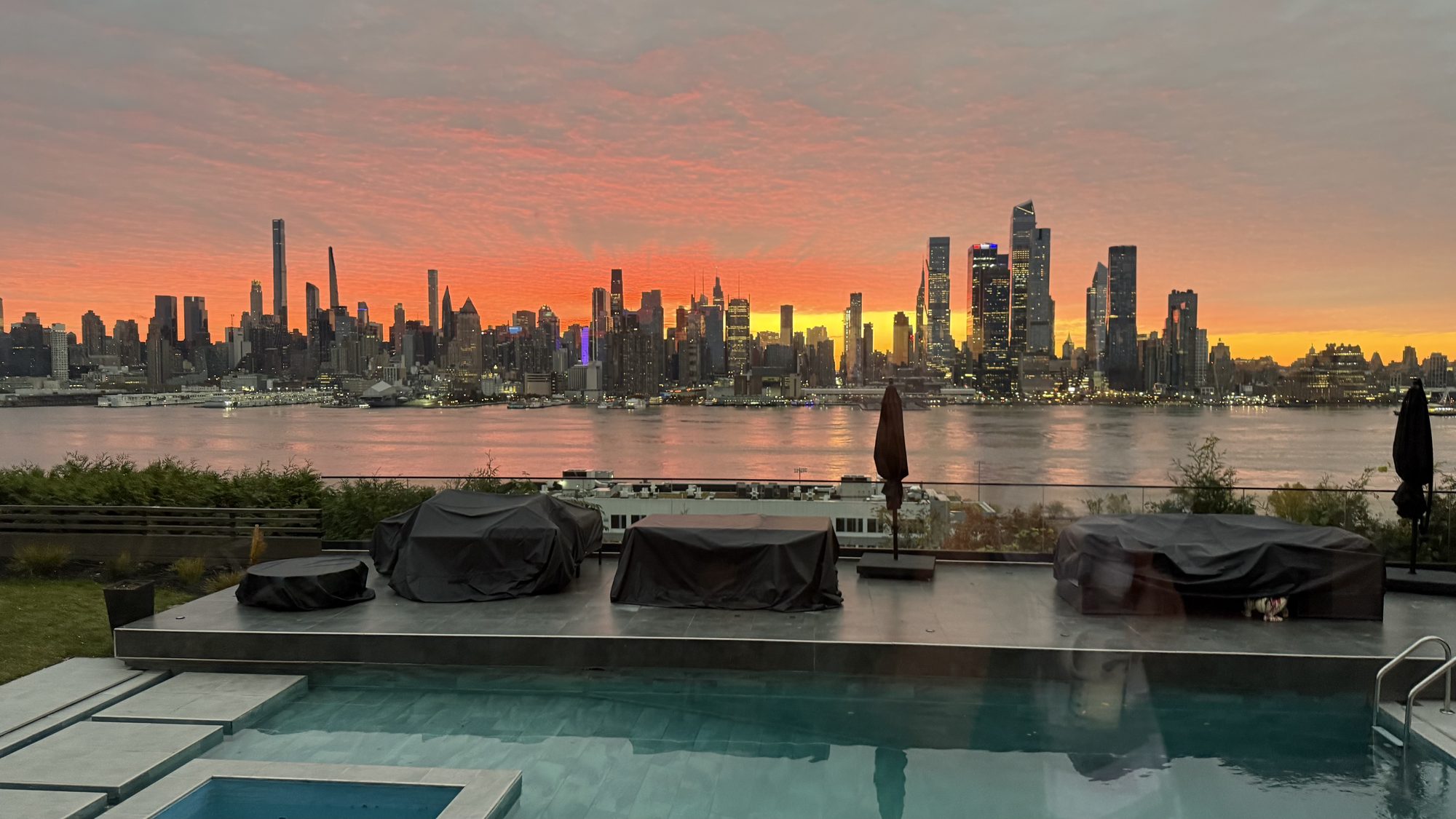 Infinity pool at sunset with Manhattan skyline